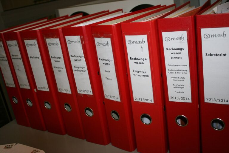 Czerwone segregatory z dokumentami ustawione na polce